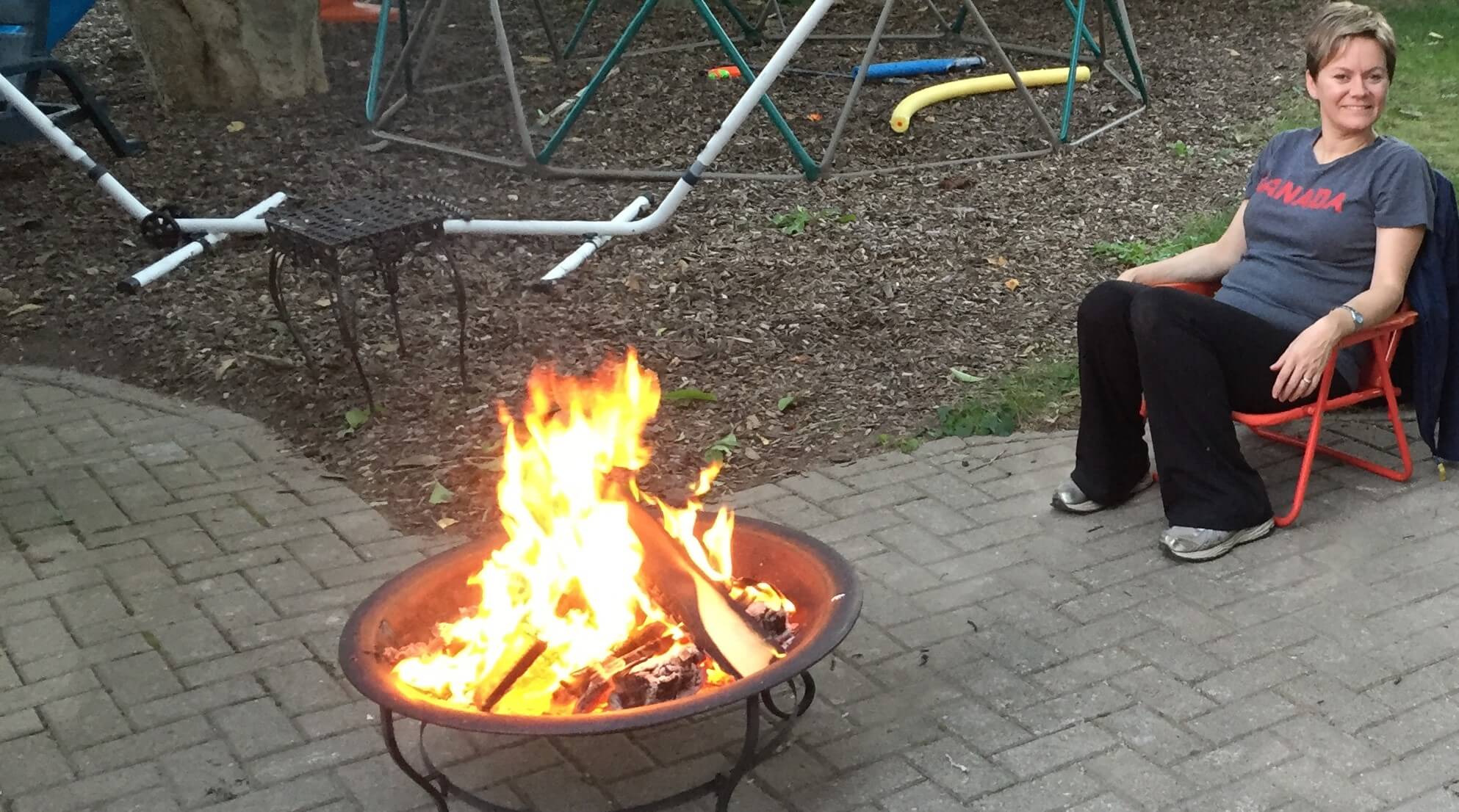 hannah-brown-sitting-by-backyard-campfire